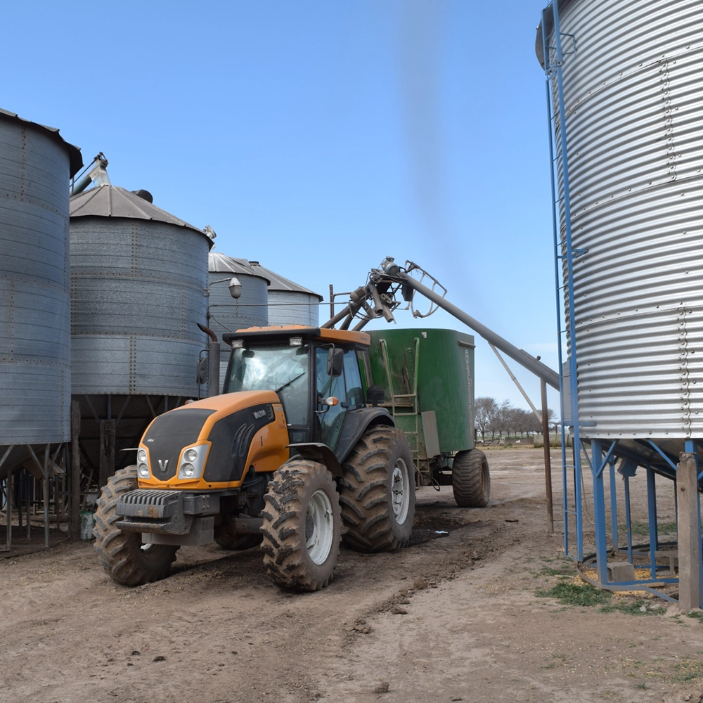 Tractor con mixer junto a los silos